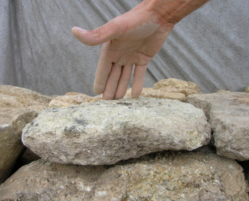Geste lié à la vérification de l’assise de pose d’une pierre et de son équilibre sur le rang de dessous. L. Cagin – L. Nicolas, 2008 © (Association Une pierre sur l’autre)